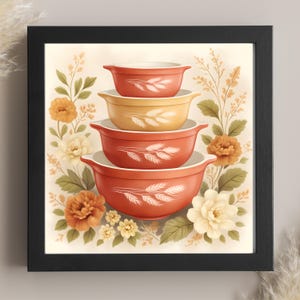 Könnte beinhalten: Gerahmter Kunstdruck mit einem Stapel von vier Retro-Rührschüsseln in Rot- und Gelbtönen. Jede Schüssel hat einen weißen Innenraum und ein Weizenähren-Design. Die Schüsseln sind von floralen Elementen in Orange, Gelb und Grün umgeben.