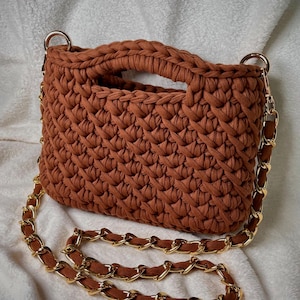 以下が含まれることがあります： 黒い持ち手と「But First, Coffee」の文字が黒い手書き風フォントで書かれた白いセラミックマグ。マグカップは白い表面に置かれています。