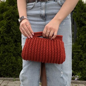 Handmade crochet clutch bag featuring a modern ribbed texture and minimalist design. Stylish crocheted purse made from chunky yarn, perfect for everyday wear, special occasions, and evening outings. The elegant rectangular shape adds a contemporary touch to any outfit. Detailed crochet stitches create a unique texture that makes this bag both fashionable and eye-catching.