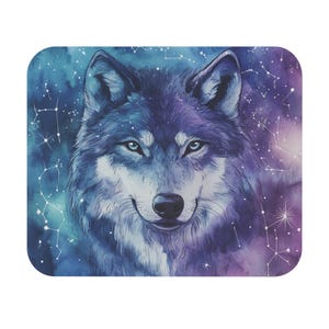 May include: A square mousepad featuring a watercolor illustration of a wolf with blue eyes. The wolf is depicted against a backdrop of a starry night sky in shades of blue, purple, and white. Constellations are visible.
