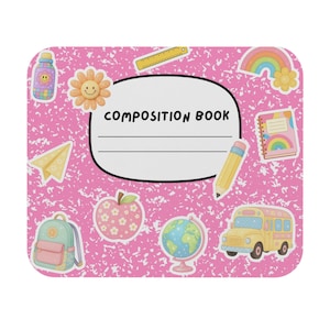 May include: A pink composition book with a white oval label that reads "COMPOSITION BOOK". The cover is decorated with school-themed stickers, including a yellow school bus, a pencil, and a globe.