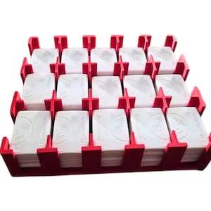 May include: A red plastic storage case with 16 compartments, each holding a stack of white rectangular cards. The cards have the word "Remarkable" printed on them.