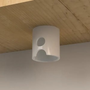 Op de afbeelding: Witte plastic plafond gemonteerde snoerorganizer met twee gaten voor snoeren.