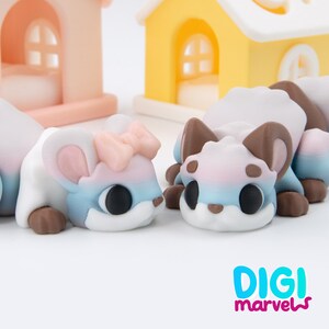 K&ouml;nnte beinhalten: Zwei kleine, stilisierte Tierfiguren mit Farbverlauf in Wei&szlig;, Rosa und Blau. Eine Figur hat eine rosa Schleife auf dem Kopf. Beide haben gro&szlig;e schwarze Augen und braune Akzente. Der Text "DIGI marvels" befindet sich in der unteren rechten Ecke.