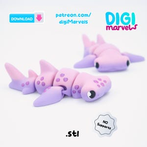 May include: A 3D-printed articulated hammerhead shark toy in shades of pink and purple. The toy is segmented, allowing for movement. The image includes the text "patreon.com/digiMarvels", "DIGI marvels", "DOWNLOAD", and ".stl".