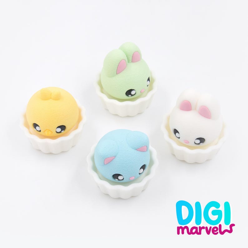 May include: Four colourful, cartoon-style animal figures in white, scalloped cups. The animals include a yellow chick, a green bunny, a blue cat, and a white bunny. The Digi Marvels logo is in the bottom right corner.