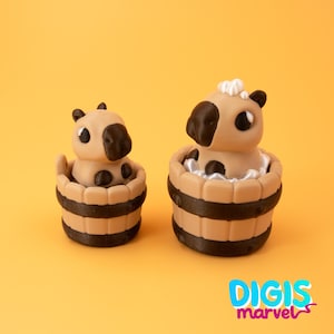 May include: Two tan and brown capybara figurines in wooden tubs with dark brown stripes. One has a white fluffy accent on its head. The background is a solid orange color. The text "DIGIS marvel" is in the bottom right corner.