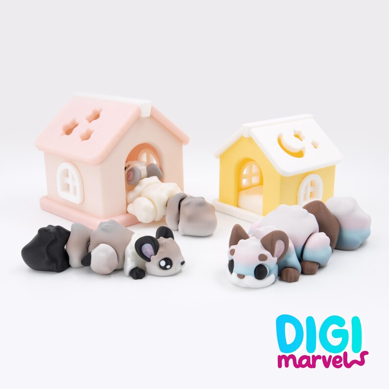 K&ouml;nnte beinhalten: Zwei kleine, bewegliche Tierfiguren mit Farbverlauf, eine in Braun- und Wei&szlig;t&ouml;nen, die andere in Pastellblau, Rosa und Wei&szlig;. Sie sind neben zwei Miniaturh&auml;usern platziert, eines in Hellrosa und eines in Gelb. Der Text lautet DIGI marvels.