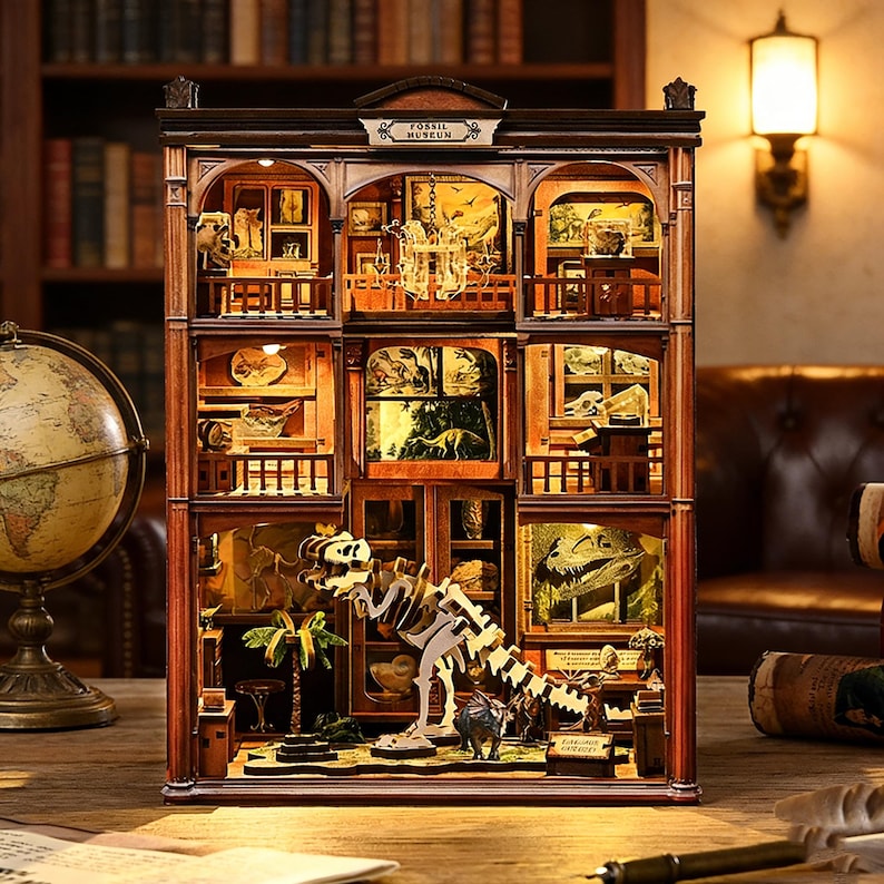 Op de afbeelding: Een gedetailleerd houten model van een fossielenmuseum, met meerdere niveaus met miniatuurexposities van dinoskeletten, fossielen en diorama's. Het model heeft een warme, uitnodigende gloed van binnenverlichting, met de tekst "Fossil Museum" op de gevel.