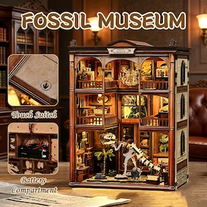 Op de afbeelding: Een gedetailleerd houten model van een Fossil Museum met de tekst "FOSSIL MUSEUM" bovenaan. Het model heeft meerdere verdiepingen met miniatuurexposities, een dinosaurus skelet, een aanraakschakelaar en een batterijcompartiment. Het model is verlicht met warme verlichting.