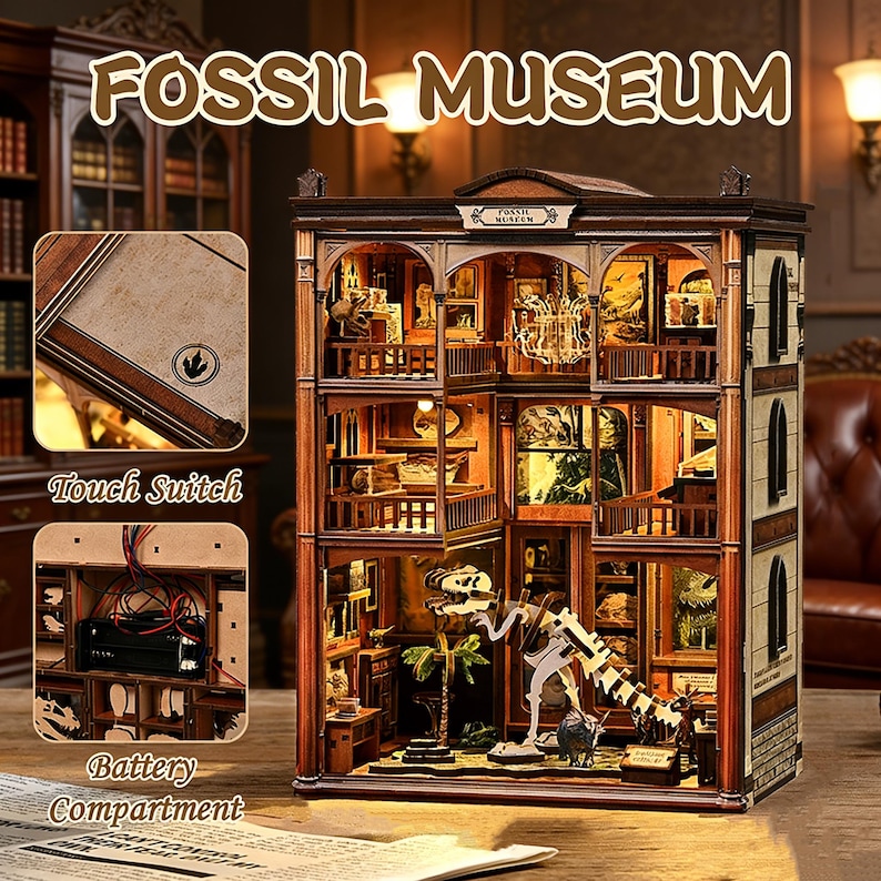 Op de afbeelding: Een gedetailleerd houten model van een Fossil Museum met de tekst "FOSSIL MUSEUM" bovenaan. Het model heeft meerdere verdiepingen met miniatuurexposities, een dinosaurus skelet, een aanraakschakelaar en een batterijcompartiment. Het model is verlicht met warme verlichting.