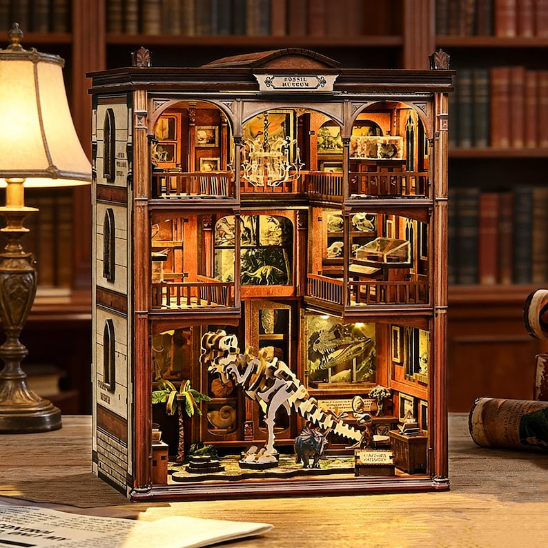 Op de afbeelding: Gedetailleerd houten model van een fossielenmuseum, met meerdere verdiepingen en miniatuurexposities, waaronder dinosaurus skeletten en fossielen. Het gebouw heeft een donkerbruine buitenkant met boogvensters en een bord met "Fossil Museum".