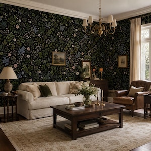 Puede incluir: Una sala de estar con papel tapiz floral oscuro con patrones botánicos verdes, azules y rosas. El espacio incluye un sofá color crema, un sillón de cuero marrón, una mesa de centro de madera oscura y una lámpara de araña de latón.