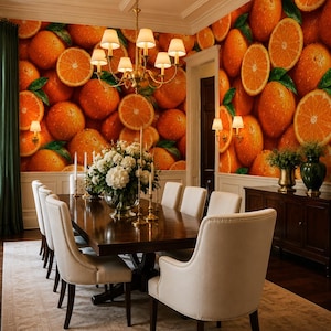 May include: A dining room featuring a wall covered in orange fruit wallpaper, a dark wood dining table, and cream-coloured upholstered chairs. A large glass vase with white flowers and gold candlesticks sits on the table under a gold chandelier.