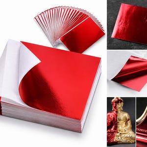 Può includere: Una pila di fogli quadrati con una finitura rossa metallizzata riflettente su un lato e un supporto in carta bianca. I fogli sono mostrati a ventaglio, singolarmente e applicati su una statua di Buddha e una cornice decorativa.