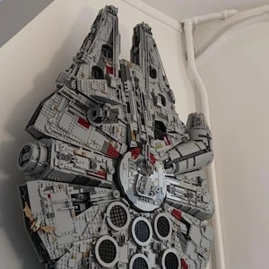 May include: A detailed model of the Millennium Falcon spaceship, constructed entirely from LEGO bricks. The model is grey and features intricate details, including the cockpit, engines, and landing gear.