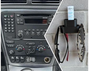 Puede incluir: Un salpicadero de coche negro con una radio, controles de clima y una palanca de cambios. El salpicadero está hecho de plástico y tiene un esquema de color negro y plateado. La radio tiene una pantalla digital y botones para sintonizar, volumen y otras funciones. Los controles de clima tienen botones para la temperatura, la velocidad del ventilador y otras funciones. La palanca de cambios es una palanca de plástico negro con una perilla plateada.