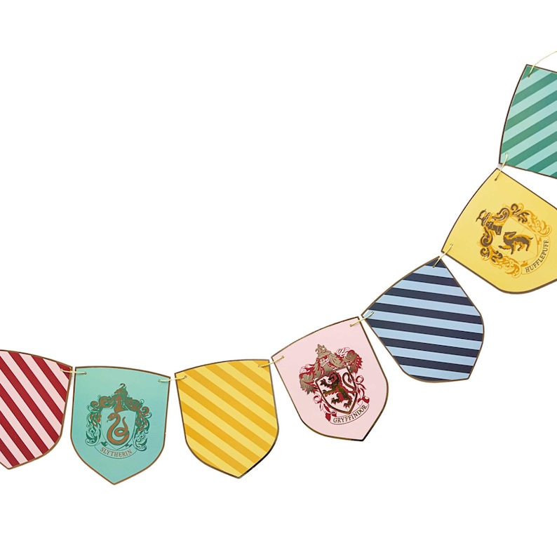 Puede incluir: Una guirnalda de banderines de colores, con los escudos de las casas de Hogwarts. Las banderas son rojas, verdes, amarillas, rosas y azules, con rayas diagonales y emblemas de las casas.