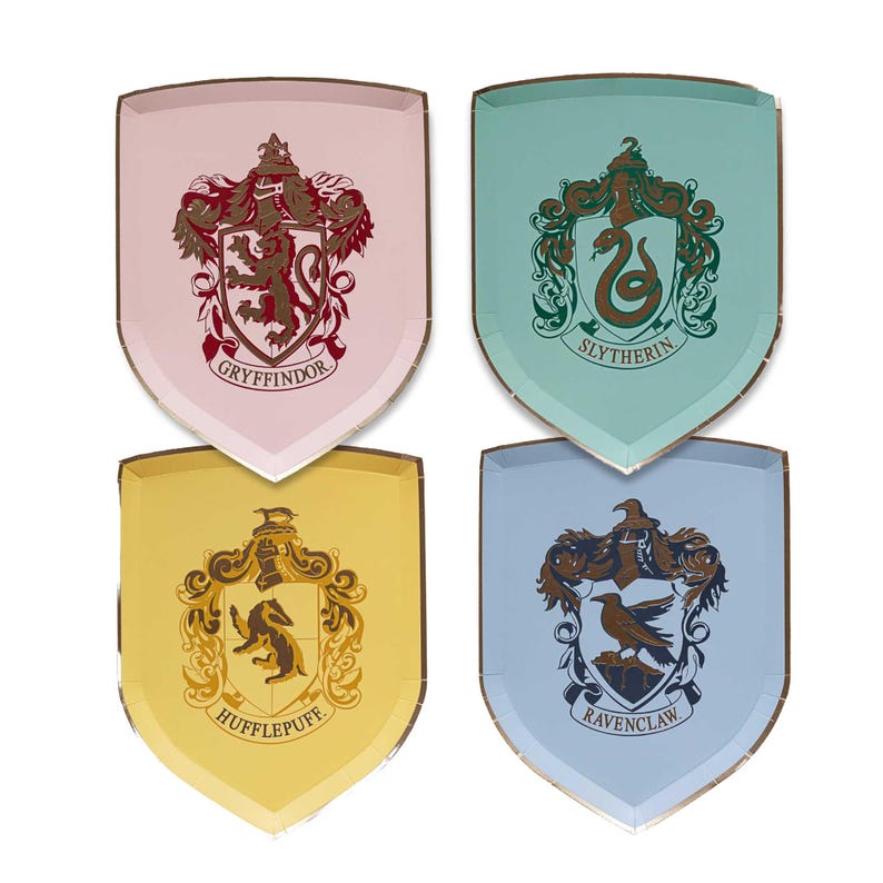 Puede incluir: Cuatro platos de papel en forma de escudo con los escudos de las casas de Hogwarts: Gryffindor, Slytherin, Hufflepuff y Ravenclaw. Cada plato tiene un fondo de color diferente y un borde dorado. Gryffindor es rosa, Slytherin es verde azulado, Hufflepuff es amarillo y Ravenclaw es azul claro.