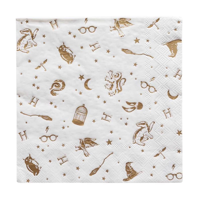 Puede incluir: Servilleta de papel cuadrada blanca con un patr&oacute;n repetido de ilustraciones doradas. El dise&ntilde;o incluye estrellas, rayos, gafas, b&uacute;hos, escobas y la letra "H".