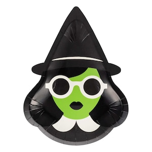 May include: Black and green witch-themed paper plate. The plate features a witch's face with white-rimmed glasses, a green face, and a black hat. The plate has a scalloped edge and is designed for Halloween or themed parties.