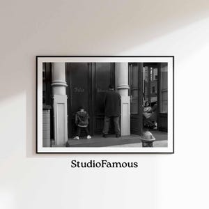 Pode incluir: Fotografia em preto e branco de uma cena de rua na cidade de Nova Iorque. Um homem e uma criança estão em frente a uma loja com as palavras "Felix" e "Delivers" escritas nas janelas.