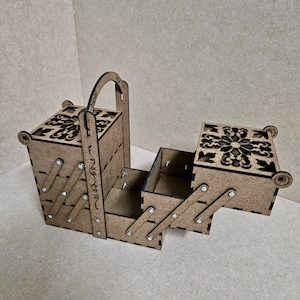 May include: A wooden folding storage box with a handle and intricate cut-out designs. The box is open and has multiple compartments.