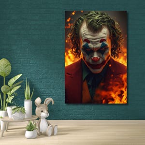 May include: A canvas print featuring a portrait of the Joker with makeup and a red suit, set against a fiery background. The artwork captures the character's intense gaze and iconic appearance.