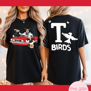 May include: Black t-shirt featuring a red car with cartoon characters on the front. The back of the shirt displays the text "T BIRDS" with a white bird graphic. The shirt is a comfortable, oversized fit.
