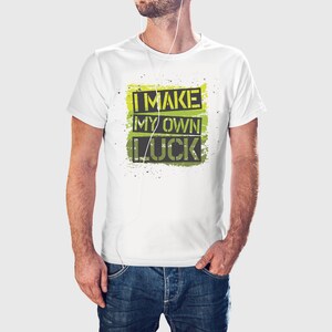 Könnte beinhalten: Weißes T-Shirt mit einem grün-gelben Grafikdruck, auf dem "I MAKE MY OWN LUCK" steht.