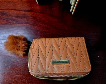 Short wallet with card compartments and coin compartment. Zipper closure with pompom. Very good quality.