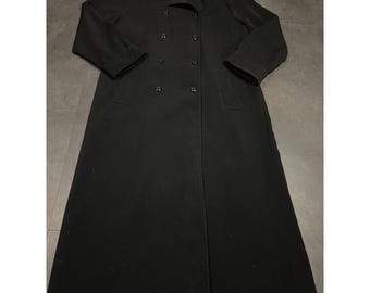 May include: A long, black double-breasted coat with a notched collar and button closures. The coat has a classic design, with a knee-length hem and long sleeves. The coat is made of a smooth, solid fabric.
