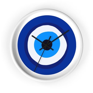 May include: White wall clock with a blue and white evil eye design. The clock has black hands.