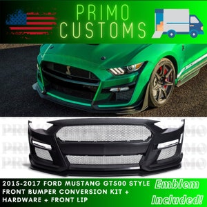 May include: A black front bumper conversion kit for a 2015-2017 Ford Mustang GT500. The kit includes a black front bumper with a honeycomb grille, a front lip, and hardware. The kit is shown installed on a green Mustang.