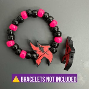 May include: Black and pink beaded bracelet with a red and black 3D printed charm. The charm is shaped like a stylized letter "K". The text "BRACELTES NOT INCLUDED" is visible at the bottom of the image.