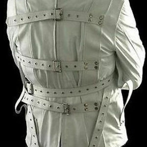 May include: White leather restraint jacket with multiple straps and buckles. The jacket has long sleeves and is fastened at the front with a zipper.