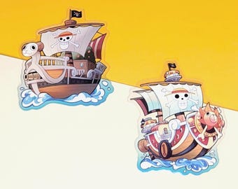 May include: Two clear stickers of cartoon pirate ships. The ships have white sails with a skull and crossbones design. The ships are brown, red, and yellow with blue water around the base. A black flag with a skull and crossbones is on top.