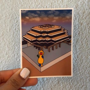 May include: A sticker featuring a stylized illustration of a building with a tiered roof and a cartoon character. The building is brown and gray, set against a sky with orange and blue hues. The cartoon character is yellow, orange, blue, and green.