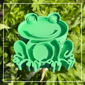 Könnte beinhalten: Ein Set aus drei Keramikbechern mit gesprenkelter, matter Oberfläche. Die Becher sind in Creme-, Hellgrau- und Dunkelgrautönen gehalten. Jeder Becher hat ein schlichtes, minimalistisches Design und einen abgerundeten Henkel.