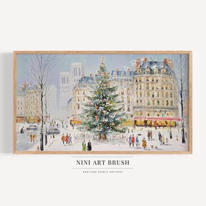Puede incluir: Una pintura enmarcada representa una escena de calle parisina nevada con un árbol de Navidad decorado. Los edificios bordean la calle y la gente camina. La obra de arte está firmada "NINI ART BRUSH" y es una pieza de "HERITAGE PRINTS ARTISTRY".