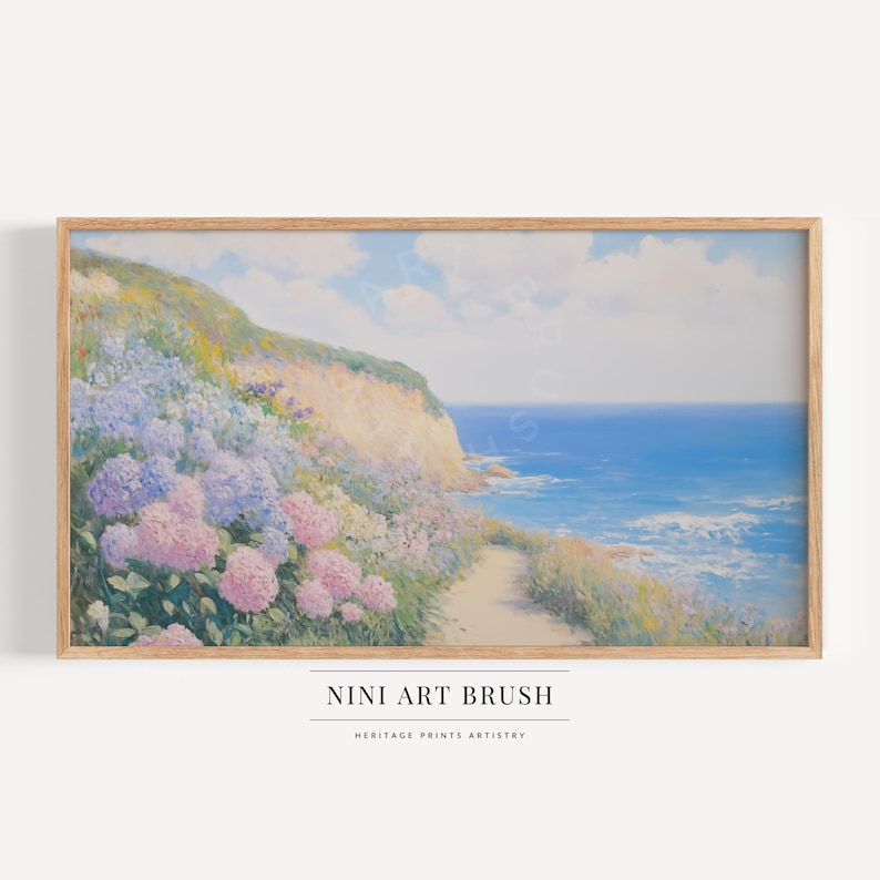 Op de afbeelding: Een ingelijste landschapsafdruk met een kusttafereel, met een pad dat naar de oceaan leidt. Het kunstwerk toont een klif bedekt met kleurrijke bloemen, met de zee en de lucht op de achtergrond. De tekst "NINI ART BRUSH" staat onderaan.