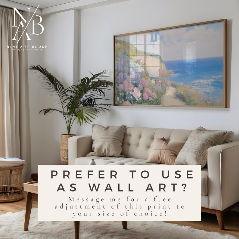 Op de afbeelding: Een ingelijste landschapsafdruk hangt boven een beige bank met kussens. De afdruk toont een kustlandschap met een pad, bloemen en de zee. Tekst op de afbeelding luidt "PREFER TO USE AS WALL ART?" en "NINI ART BRUSH".