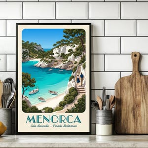 May include: Framed art print featuring a vibrant coastal scene of Menorca, Spain. The artwork depicts a turquoise bay with boats, white cliffs, and lush greenery under a bright blue sky. The word "MENORCA" is displayed at the bottom.