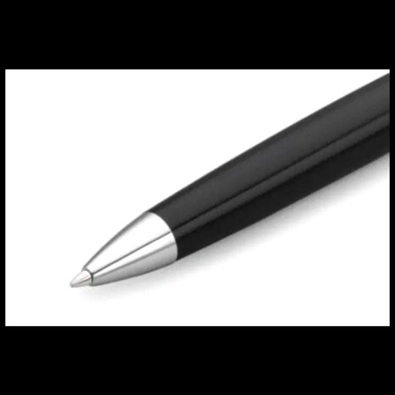 K&ouml;nnte beinhalten: Ein schwarzer Kugelschreiber mit silberner Spitze. Der Stift hat eine glatte, gl&auml;nzende Oberfl&auml;che und ein schlichtes, elegantes Design. Der Stift ist diagonal vor einem wei&szlig;en Hintergrund angeordnet.