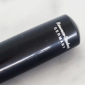 K&ouml;nnte beinhalten: Nahaufnahme eines schwarzen Stifts mit dem wei&szlig;en Aufdruck "Kaweco Student GERMANY". Der Stift hat eine glatte, gl&auml;nzende Oberfl&auml;che und eine abgerundete Spitze. Der Stift ist leicht angewinkelt, wodurch die Schrift auf der Seite zu sehen ist.