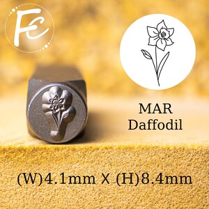 May include: A metal stamp with a daffodil design. The stamp is 4.1 mm wide and 8.4 mm high. The stamp is used to create impressions in metal.