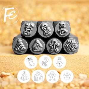 May include: A set of metal stamps with Christmas-themed designs, including a stocking, candy cane, snowman, Christmas tree, gingerbread house, gingerbread man, and snowflake. The stamps are arranged in two rows, with the designs also shown in a circular format.