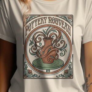 May include: Cream-colored t-shirt featuring a circular graphic with the text "Pottery Rouvern." The graphic depicts a brown vase with green leaves and vines, set on a green pottery wheel. The design is framed with floral accents.