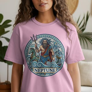 Pink t-shirt with circular Neptune design featuring a merman, horses, and dolphins.