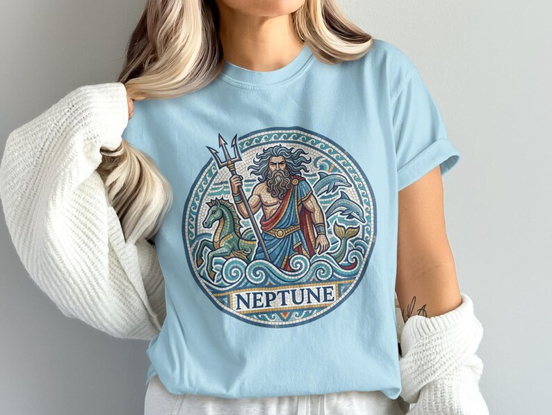 Light blue t-shirt with circular mosaic art of Neptune holding a trident, with horses and dolphins.